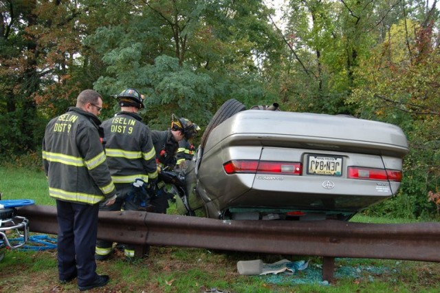 FF/EMT Bennett and Captain Kennedy use the Jaws to extricate the driver of this MVA-flipper on the Garden State Parkway North ramp from Route 1 South on October 9, 2008.